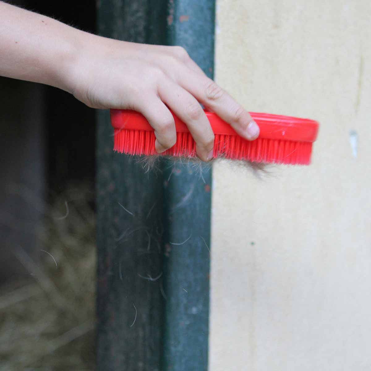Brosse pour cheval MagicBrush Pink Pony, imprimé rose, en utilisation, à l'écurie