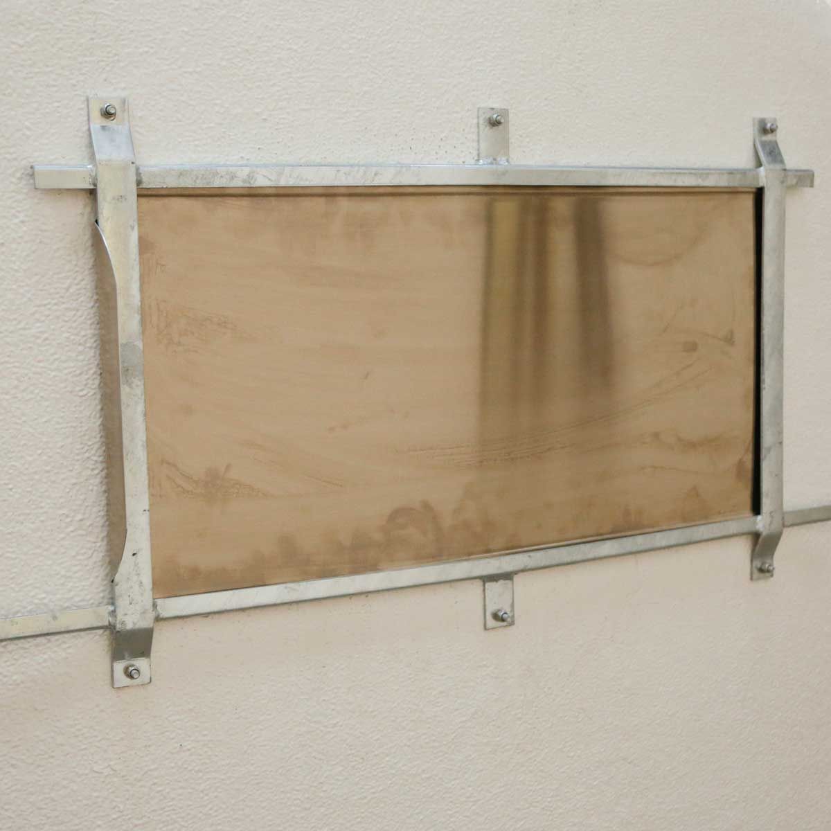 Planche en bois fixée sur un support métallique au mur