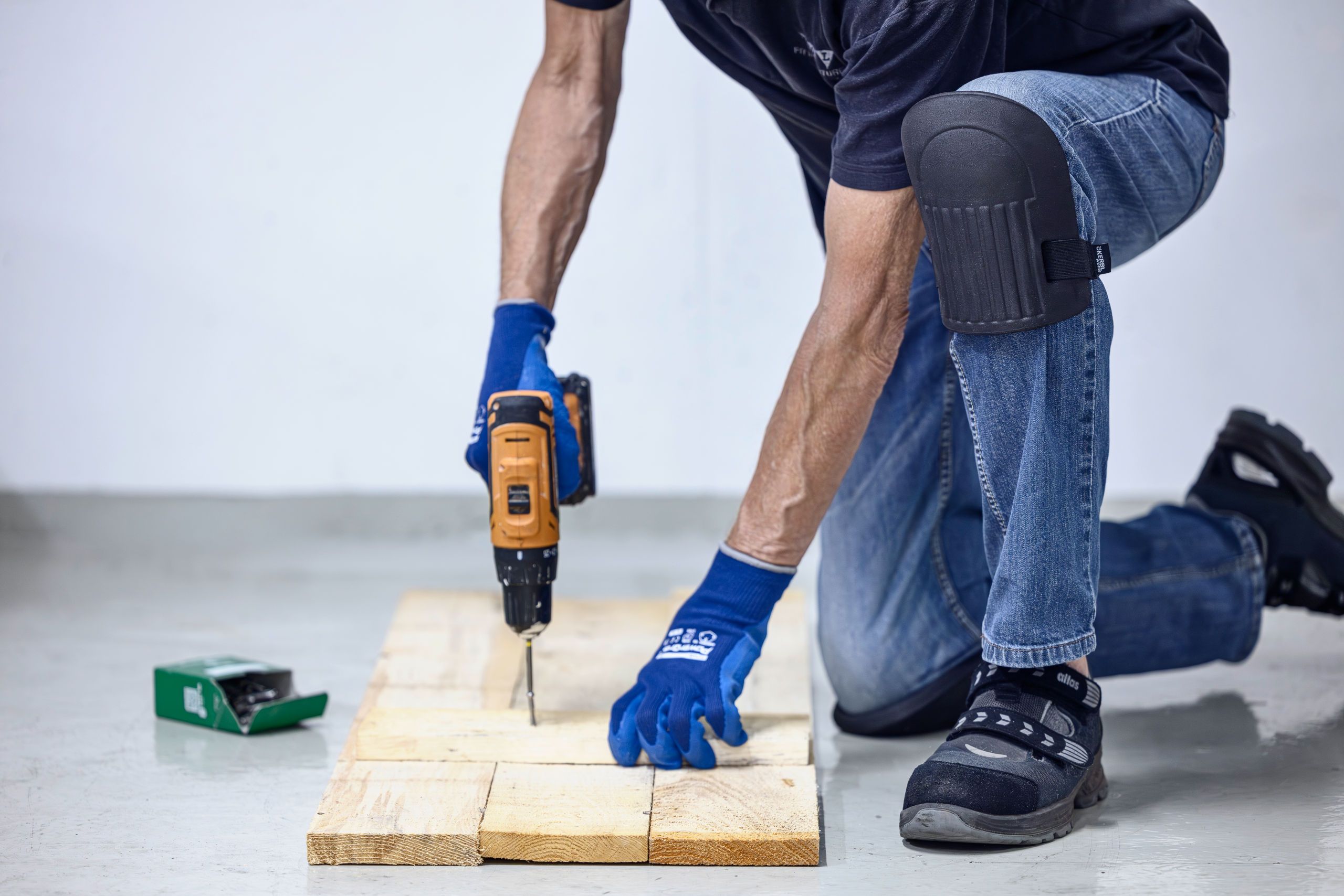 workbench, wood plank, drill, knee pad, gloves