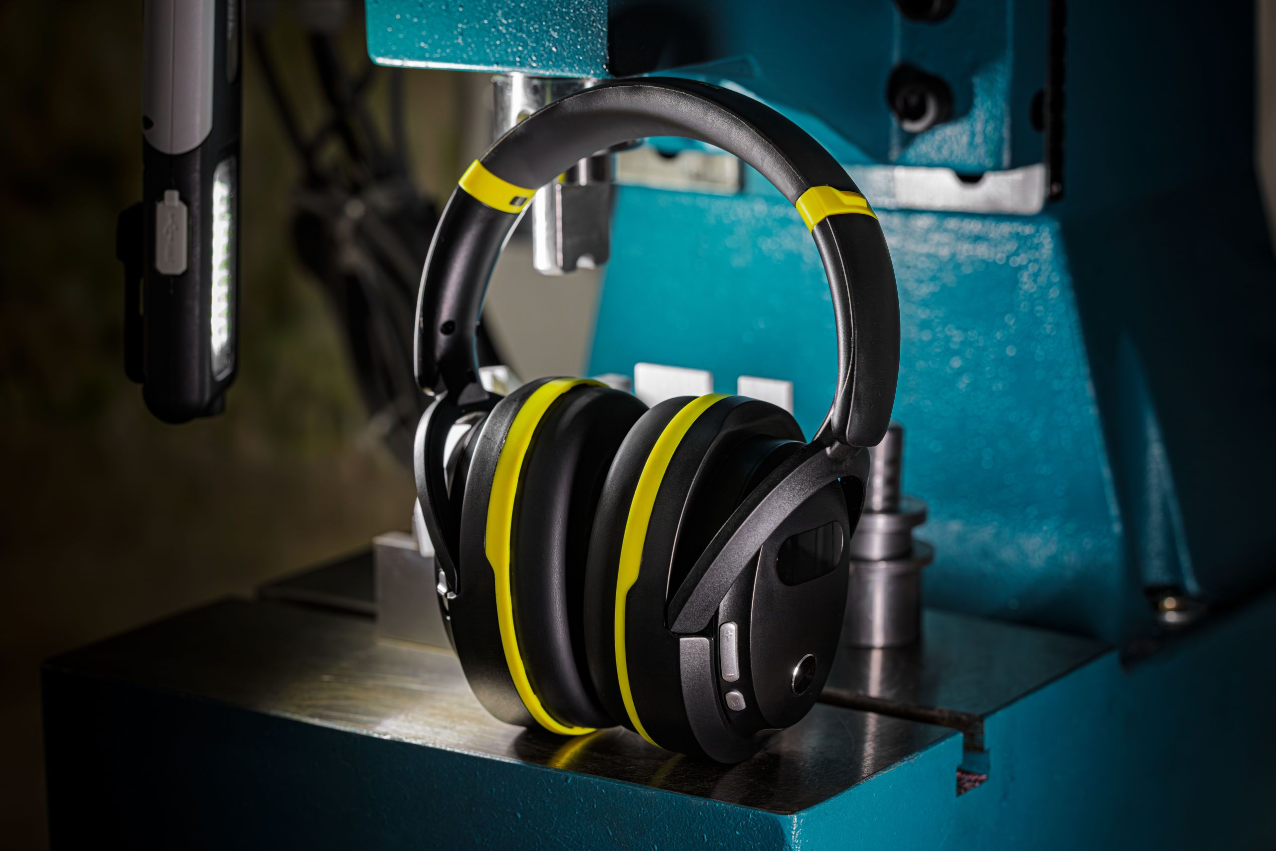 headphones, over-ear, noise-cancelling, yellow accents, industrial setup