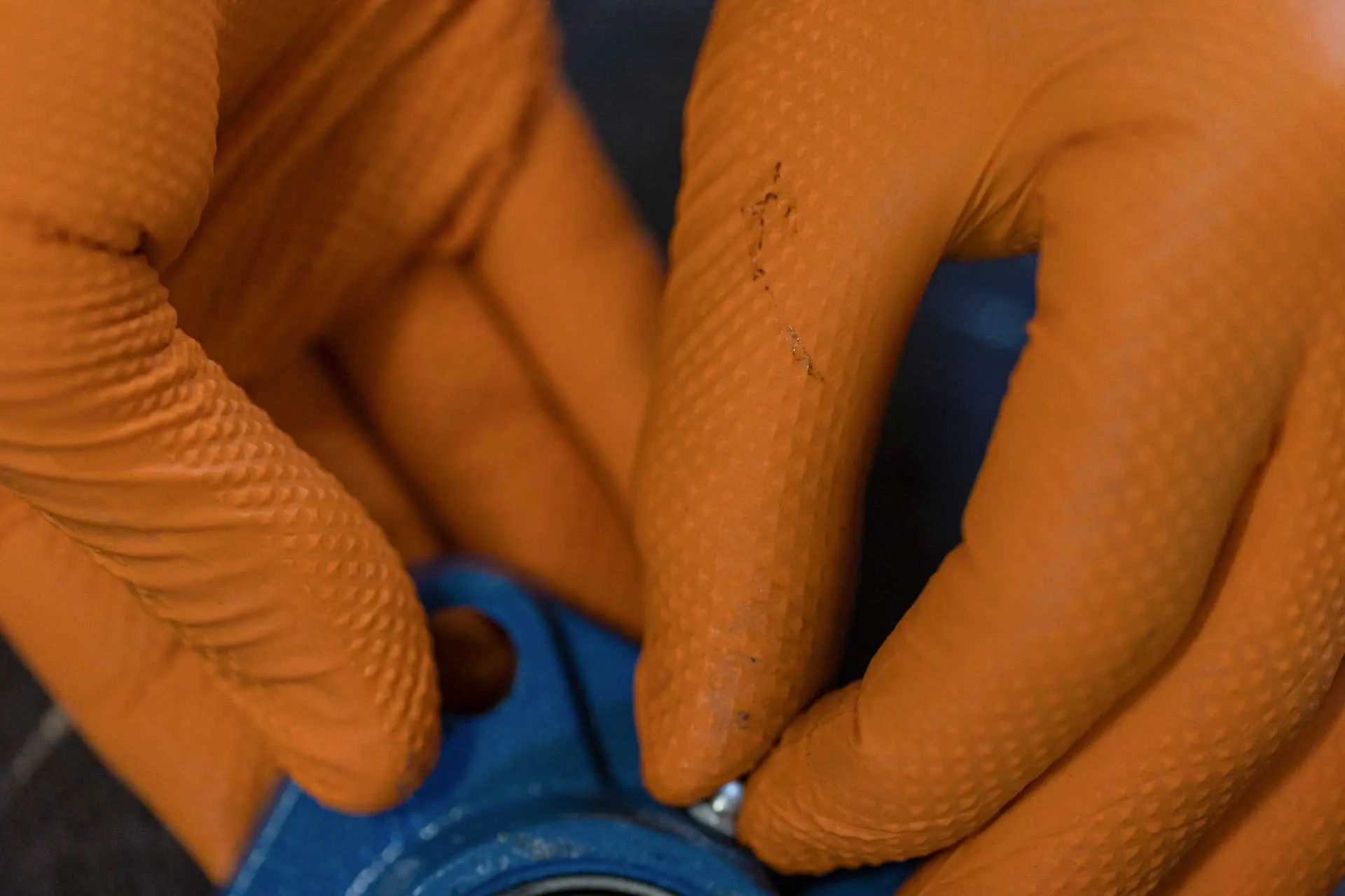 Kerbl Nitril engångshandske X-Grip, orange, halkfri, 50 st, i användning, i handen