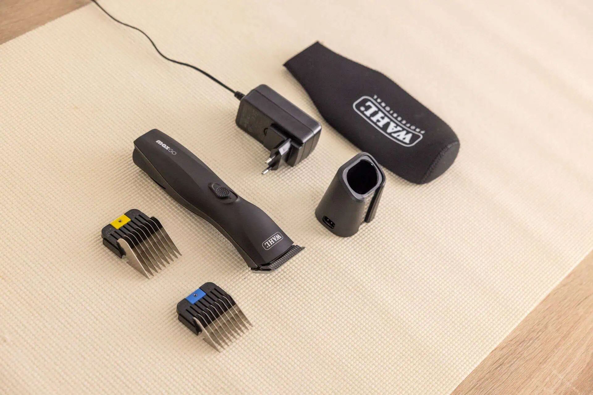 Fellschneider mit Ladekabel, zwei Aufsatzkaemmen und Etui mit Wahl Aufdruck auf Tisch